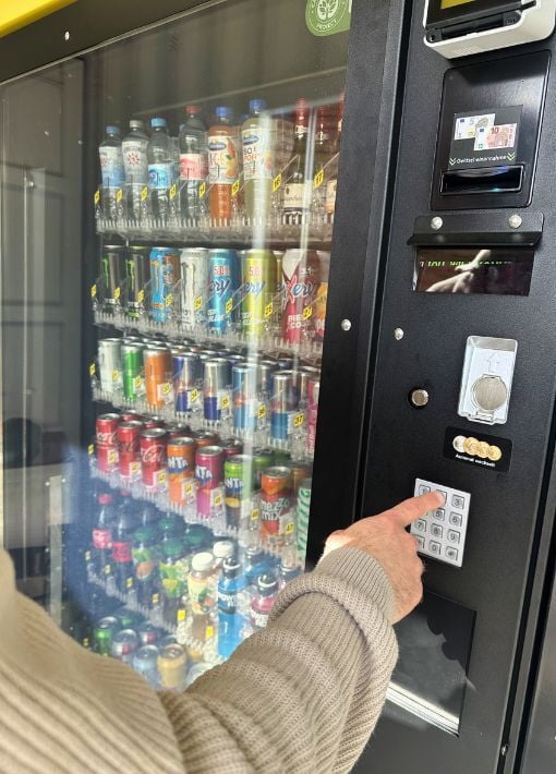 Betreiber öffnet einen Verkaufsautomaten zur Kontrolle